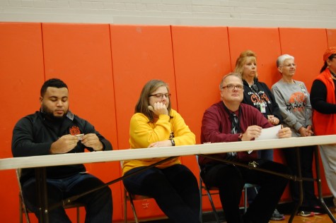 Judges of the winter pep assembly watched the pep assembly games very intently.