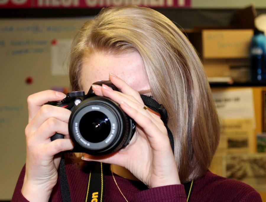 Sophomore and Co-editor Evelyn Cook takes a picture for one of her stories. All writers and editors must know how to use a camera in yearbook.