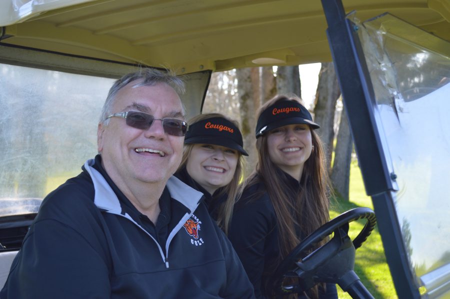 Sophomore Elise Carlson and senior Hannah Jacobs drive Coach Swanberg around the golf course, watching their teammates play in their first match.