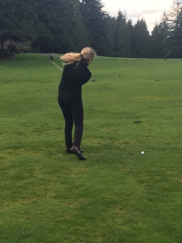 Golf player practices swinging technique.