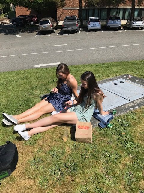 Lauren Labow(Senior) and Ryley Petoff(senior) spend theyre lunch on their phones  on a sunny day.