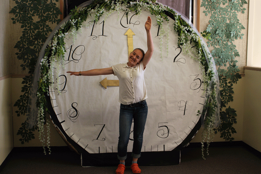 Senior posing with the clock, that goes with the prom theme
