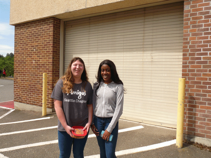 Hannah Goff and Shakhari Claiborne stand in front of the auto shop