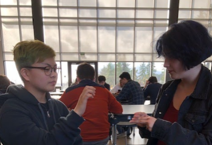 Two students, Adrienne Miller and LeiaMae Casal communicating in American Sign Language