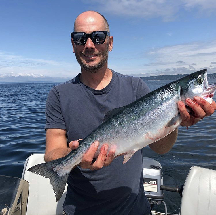 Vlach showcasing his catch during a salmon fishing trip 