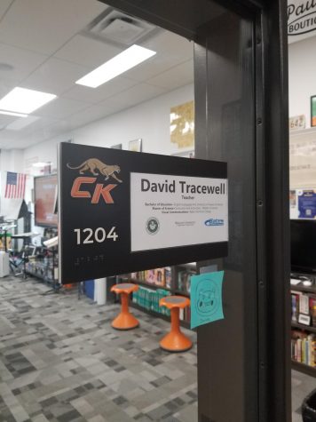 Nameplate of David Tracewells room as he teaches a class in the background.