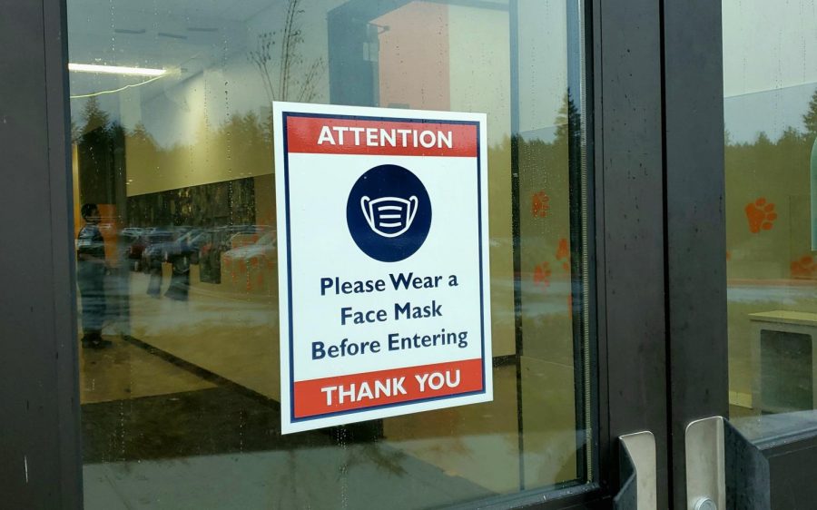 A sign that reads Please Wear a Face Mask Before Entering. These can be found on most doors to the Central Kitsap High School building.