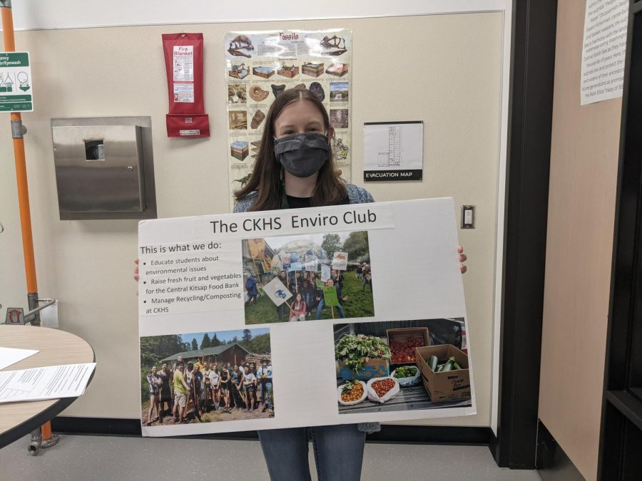 Kaitlin Caylor with the Environmental Club sign 
