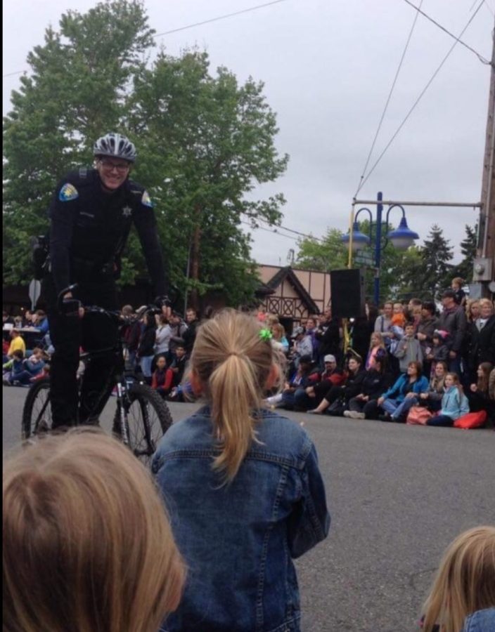 Deputy Cory Manchester  rides a bicycle in uniform at a local parade. 