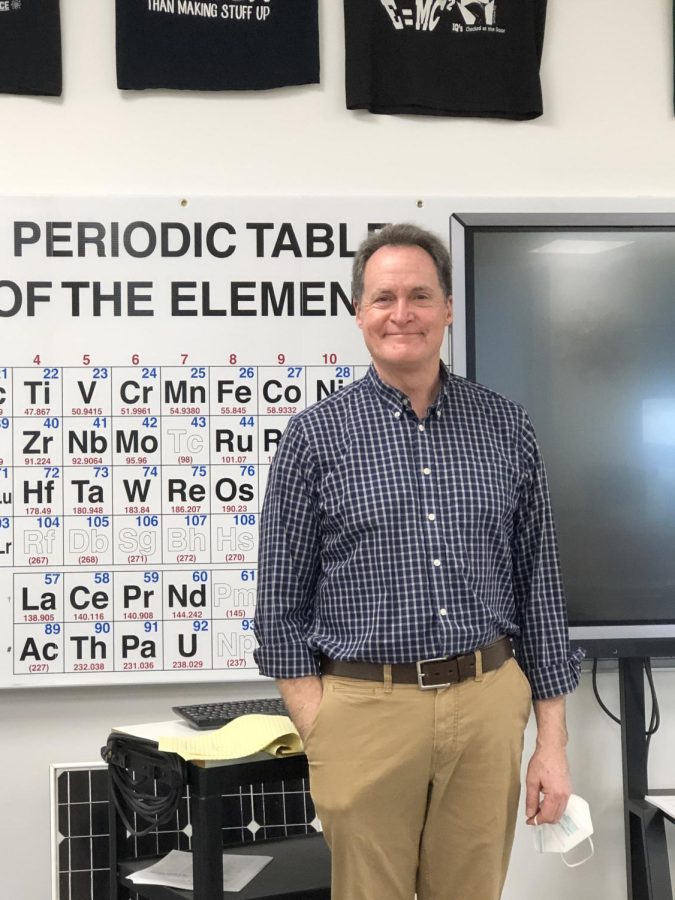 Mr. Wilson posing in front of his periodic table.