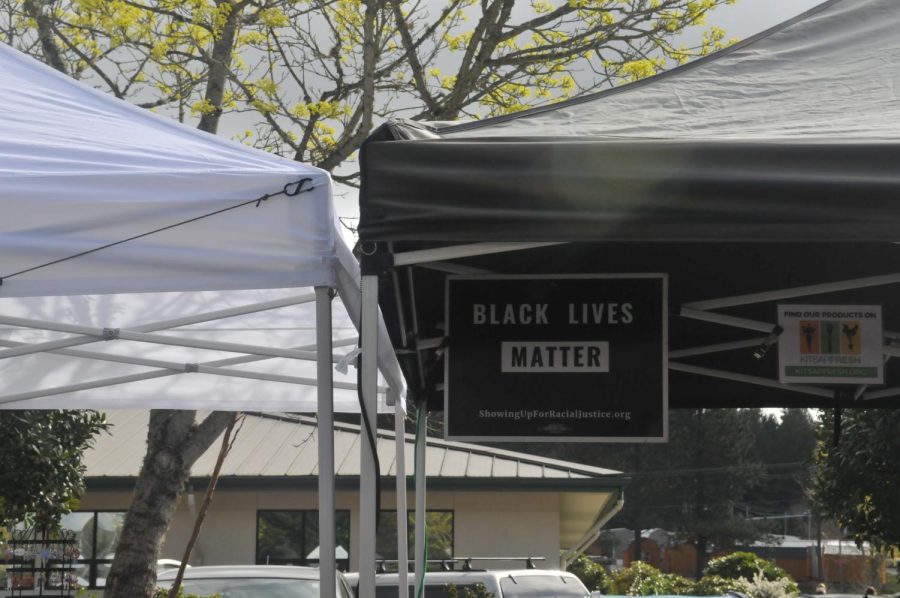 A sign reading Black Lives Matter, hangs at the top of a booth. 