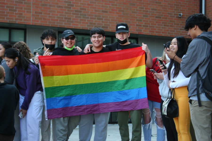 Students showing their support while holding a pride flag. 
