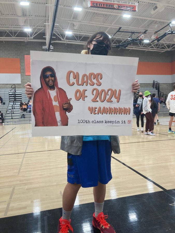 Capas, dressed up for Adam Sandler Day, holds a Class of 2024 poster.