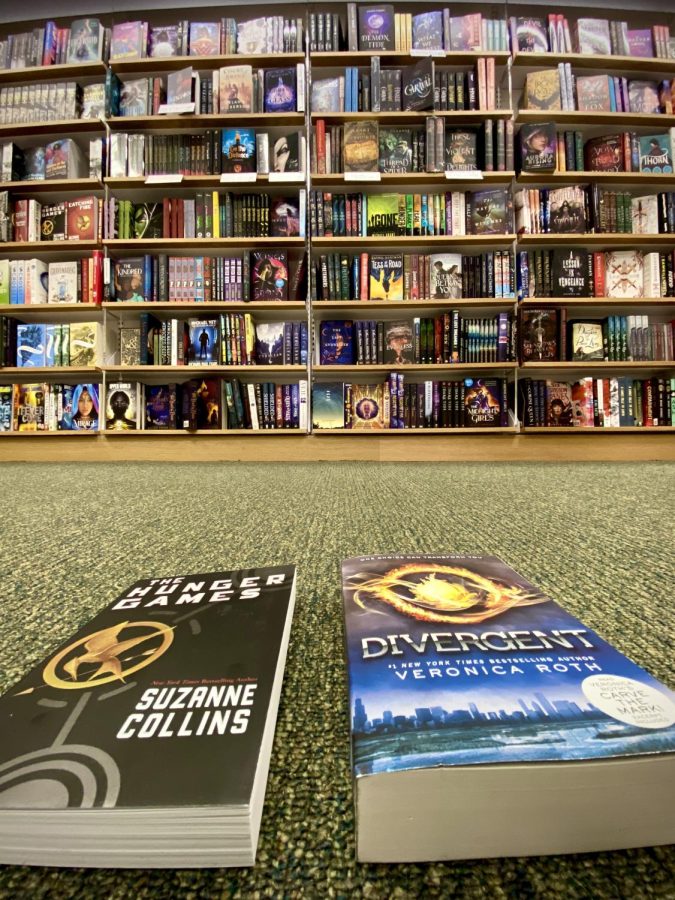 The Hunger Games by Suzanne Collins and Divergent by Veronica Roth displayed in front of the current Young Adult Sci-fi/Fantasy section at Barnes & Nobles.
