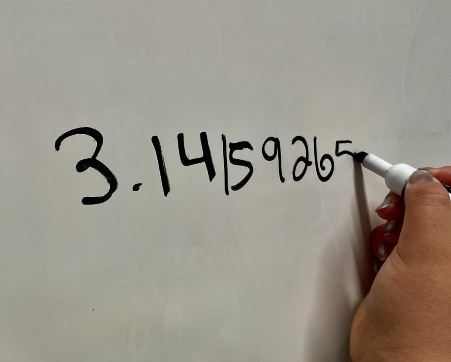 Senior Jasmine Borja reciting digits of Pi on the whiteboard in her classroom. Photo taken by Grace Vanderley
