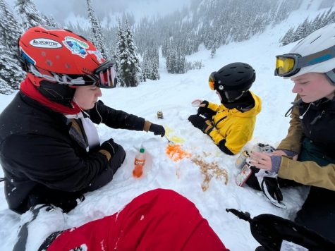 Kitsap Ski students sitting on a slope, enjoying a snow-soda (snowda) concoction