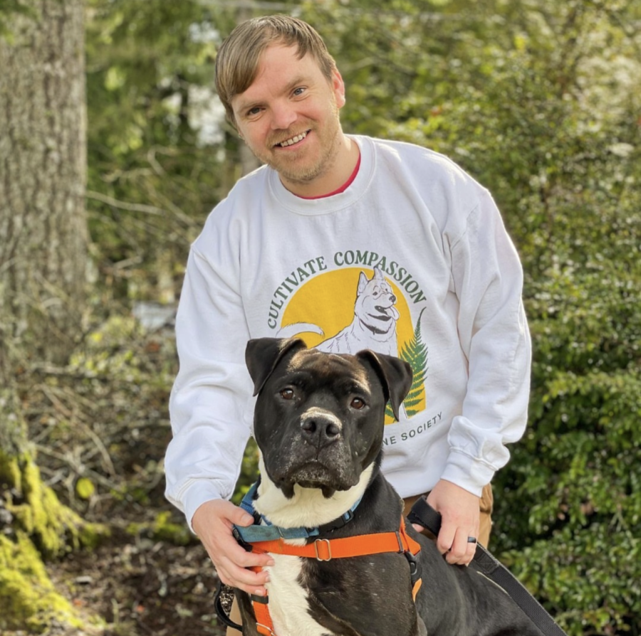 Chris Russel, the volunteer manager of kitsap humane society and a black and white dog. (Via Instagram) 