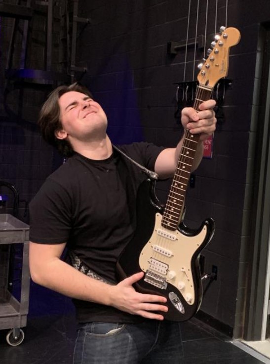 An image taken by Sotero Morales of Avery posing with his guitar during the Battle of the band rehearsal.