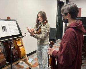 Fowler explains a violin hand position to a middle school student in the Instrumentoring Club, a club she created. (Provided by Tia-Jane Fowler)