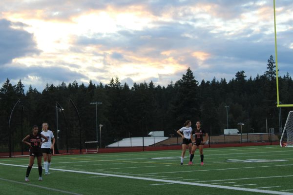 Freshmen Mailey Dayao (left) and Sonia Campbell (right) await a CK throw-in in the attacking third of Cougar Field, facing marking pressure from North Thurston defenders.