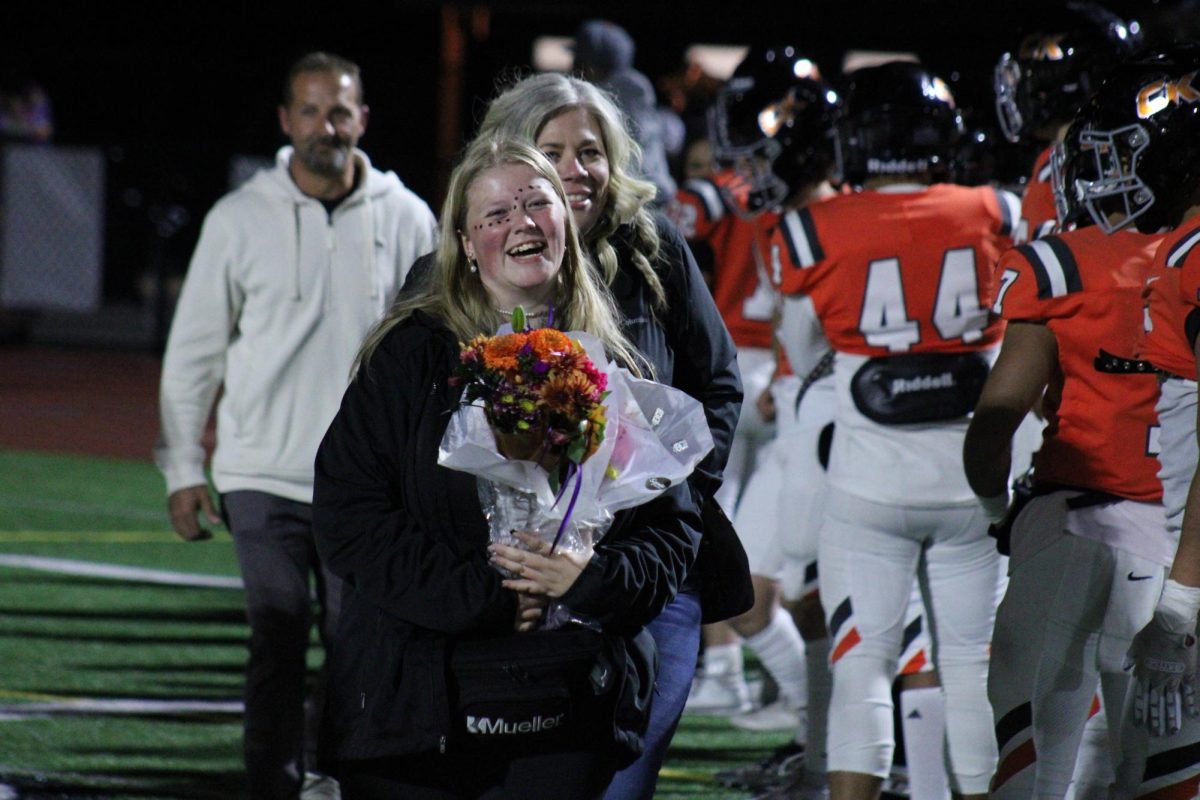 Senior football manager receives flowers and great wishes from the football team.