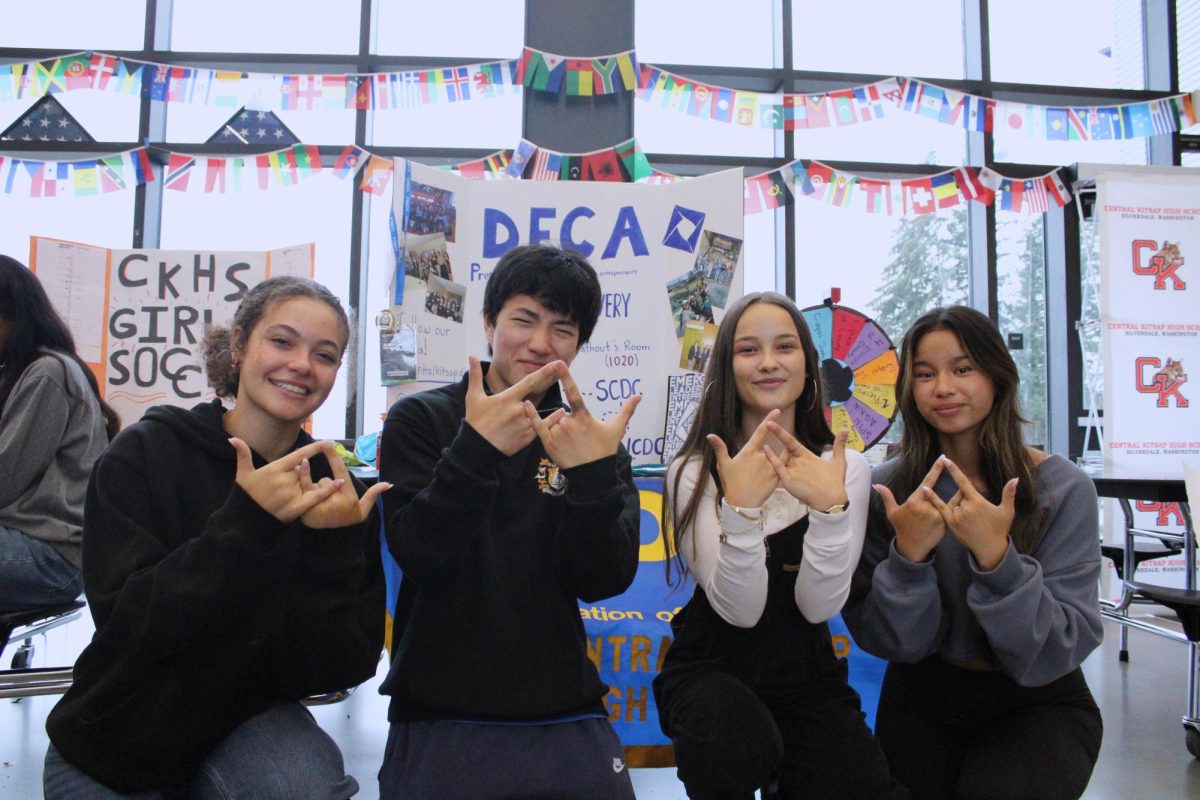 DECA Members (left to right) Cameron Tipper, Kai Livingston, Annika Pexton and MiaLei Ferruggia all posing together with the DECA hand sign up