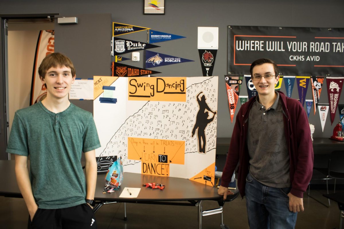 Alex Calkins (right) Zachary Christman (left) posing for a photo in front of their Maze Day trifold