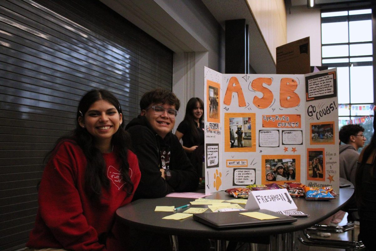 ASB Member Ambar Gaxiola (left) and Logan Johnson (right) smiling in front of the ASB table at MAZE Day