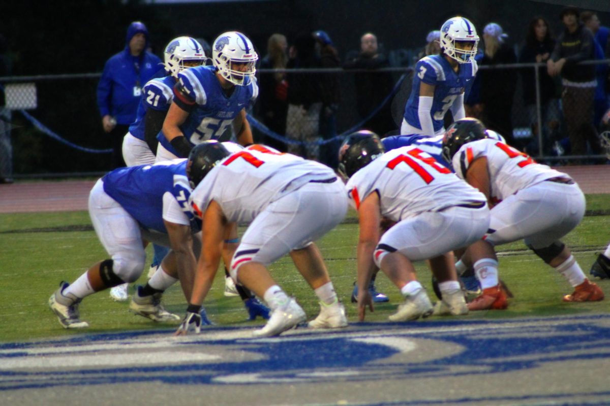 CKHS football center players get into position before a play at the Olympic stadium.