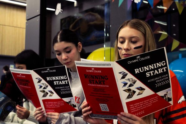 Sophomores Addyson Agpawa (left) and Lola Prouse (right) read through brochures for the Running Start program during CKHS’ annual College & Career Day event. 