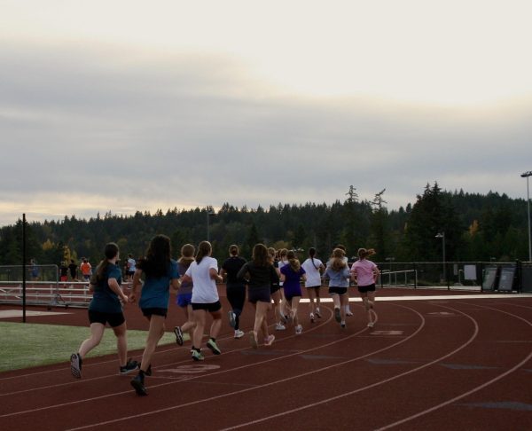 Girl’s Cross Country running laps along the track during warm-ups on Oct. 25.