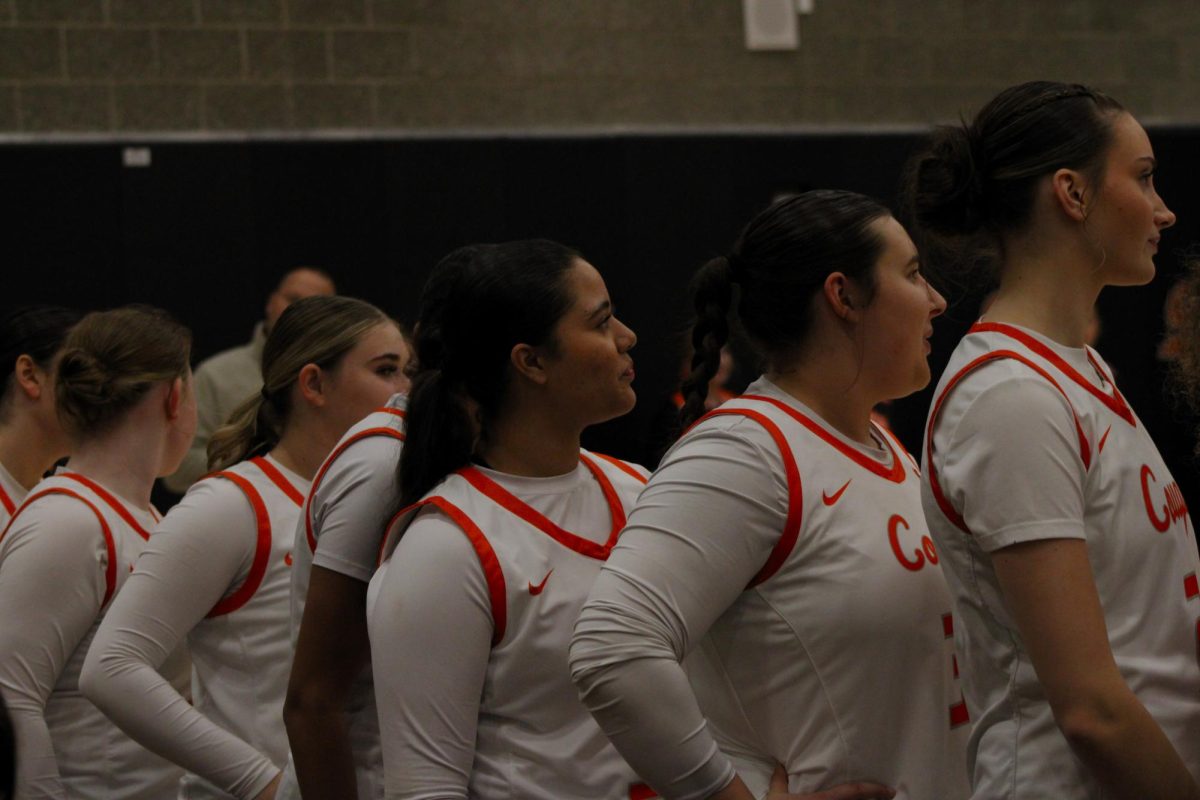 Varsity players (right to left) Alyssa Neumann, Samantha “Sam” Schaeffer, Ava Pate, Rylee Hunsaker, and Sam Hampton line up on the court before the game begins.