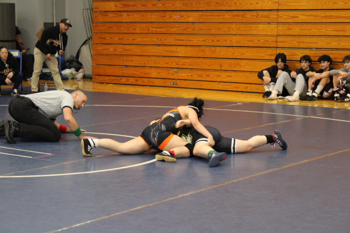 Aiysa Anderson pinning her wrestling opponent on the mat during her match.