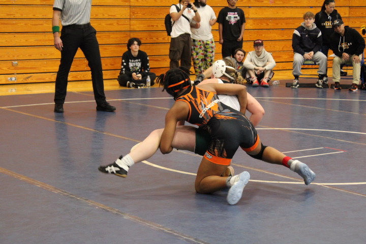 Danielle Kouamo picking up her opponent during her wrestling match before pinning her for a victory.