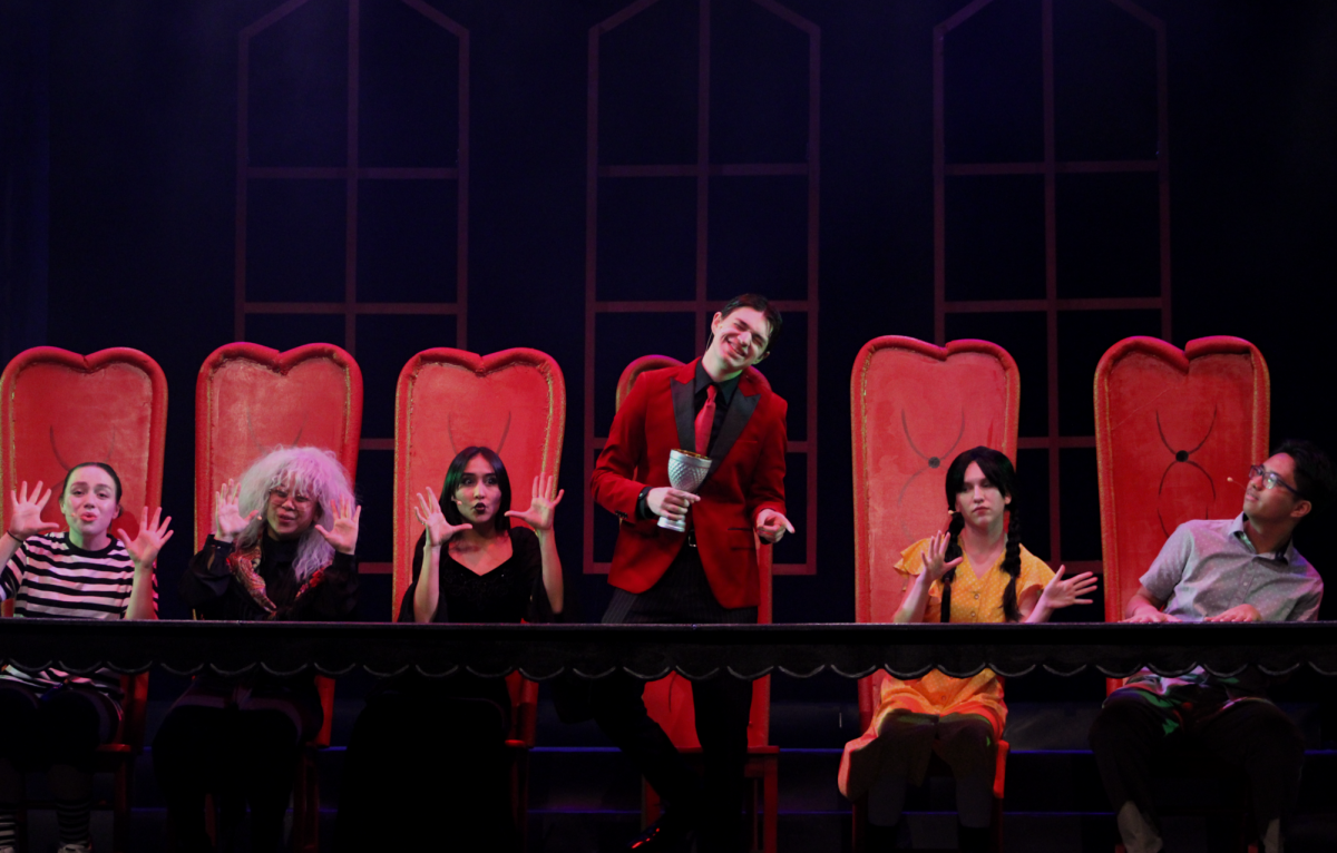 (Left to right) Lillian Johnson, Li-Mei Co, Jennaveve Hernandez, Miles Borer, Hannah Baugh, and Juancho Perez dance at the Addams family's dinner table.