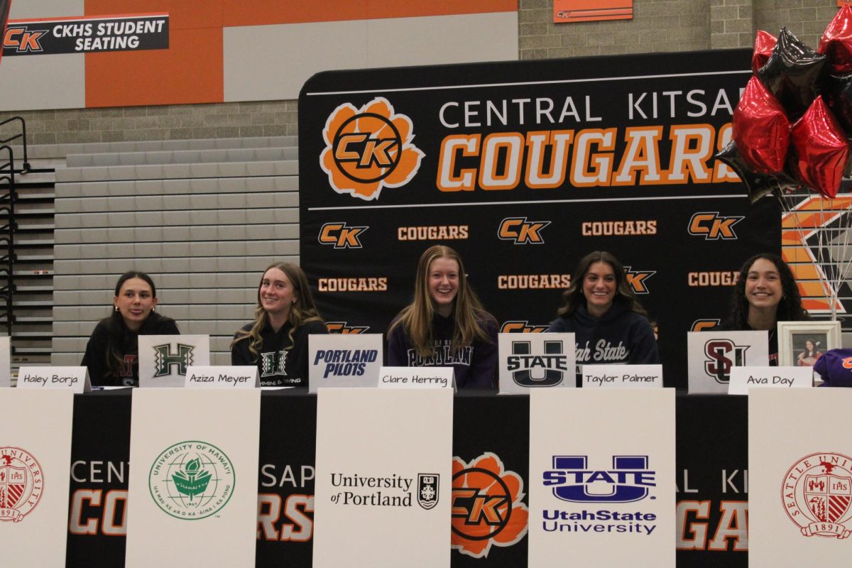 (Left to right) Haley Borja, Aziza Meyer, Claire Herring, Taylor Palmer, and Ava Day sit at their assigned seats during the signing event. 