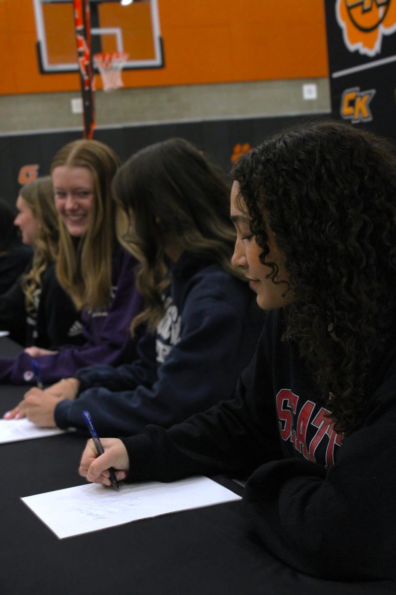 Softball athlete Ava Day signs Seattle Universities' recruitment paper.