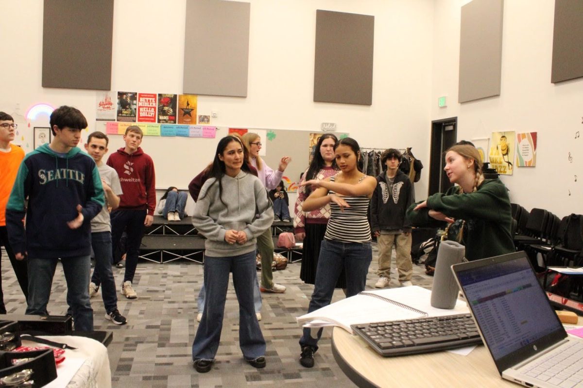 Annabelle Havers (right) demonstrates a dance move to other choir students.