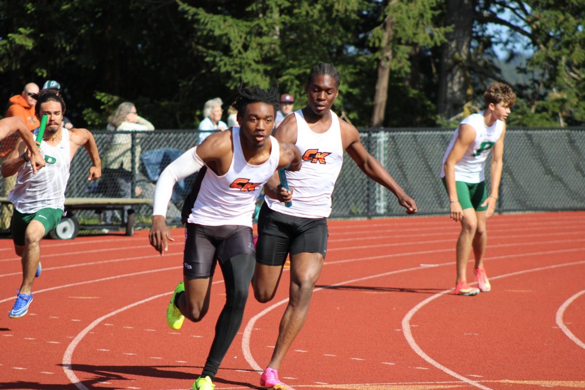 Two track teammates sprint their way to the finish line during a relay race. 
