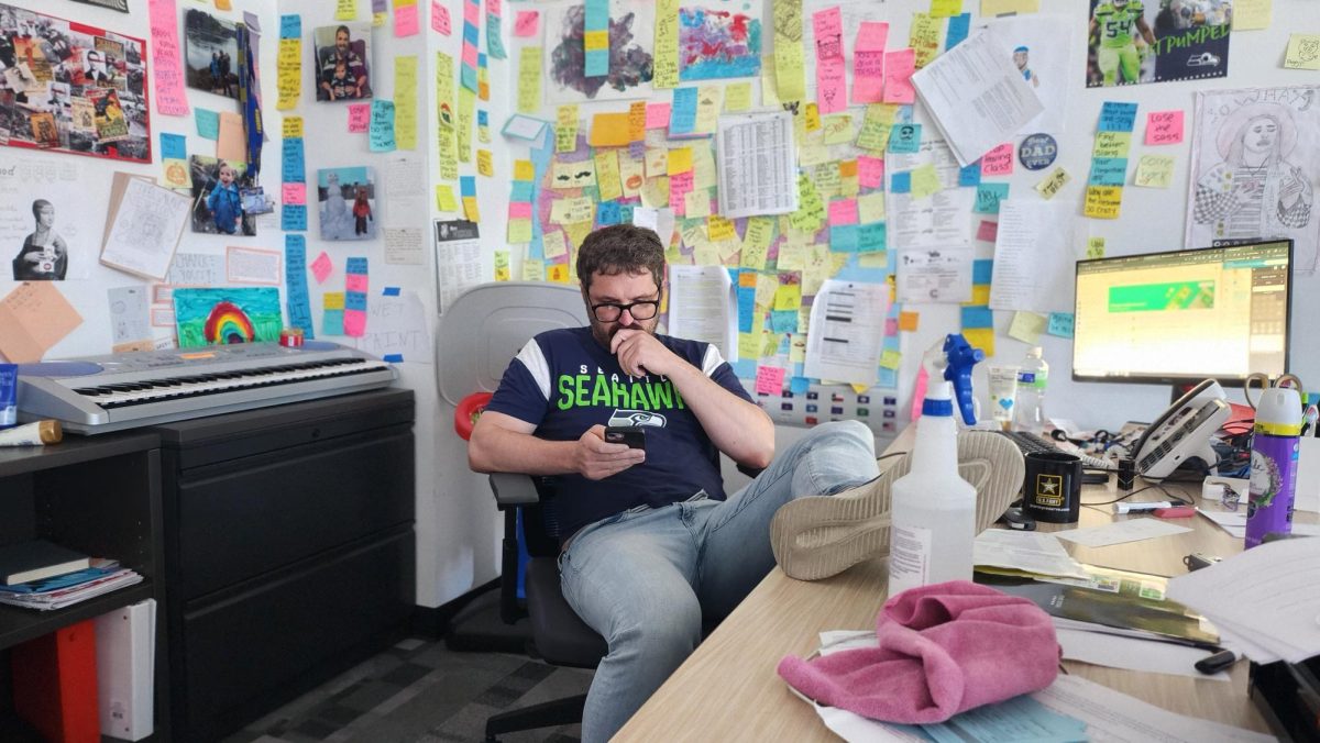Erik Randall looks at his phone after giving instruction to his class.
