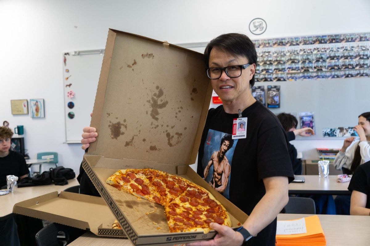 David Tracewell's Visual Communications students enjoy a pizza party provided by Anchored 4 Life as thanks for working together to create shirts for the organization. Tracewell and his students frequently fulfill project requests for both the school and its surrounding community. 