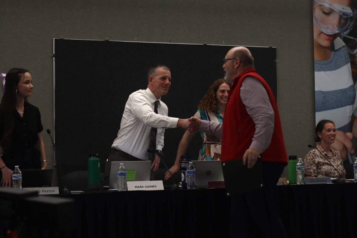 New Director Mark Gaines shakes hand with a community member.