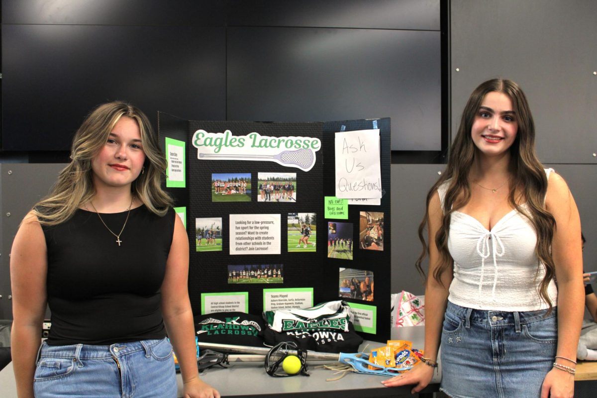 Olivia Keough (left) and Trinity Ranes (right) stand in front of their trifold.