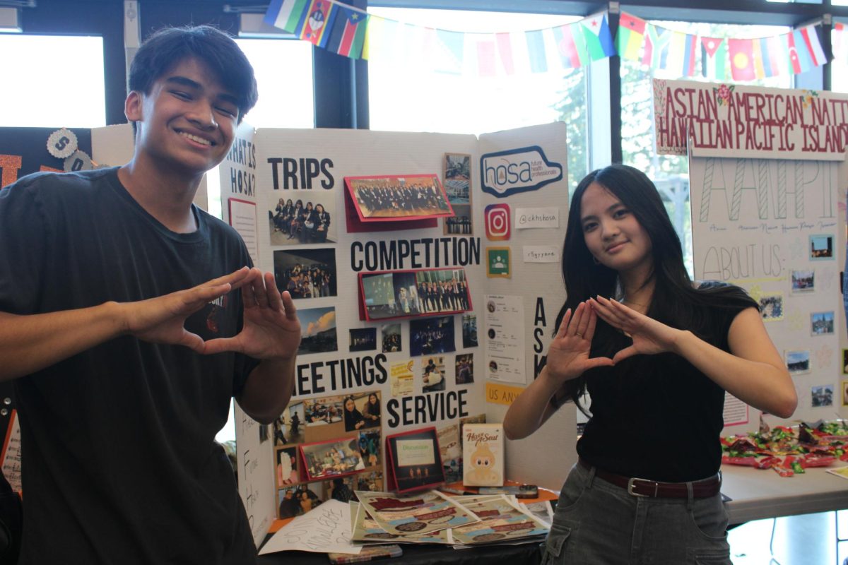 Kaden Atendido (left) and Sophia Jingco (right) pose in front of their booth.