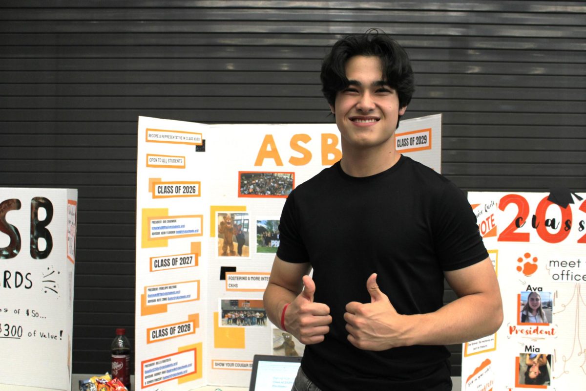 Nicholas Brazier poses in front of the Associated Student Body trifold.