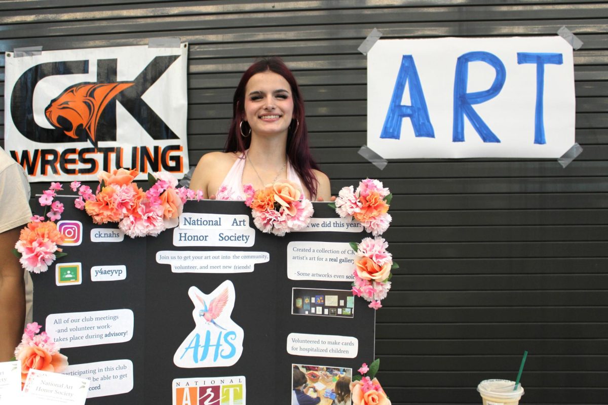 Madeline Johnson stands behind the National Art Honors Society booth.