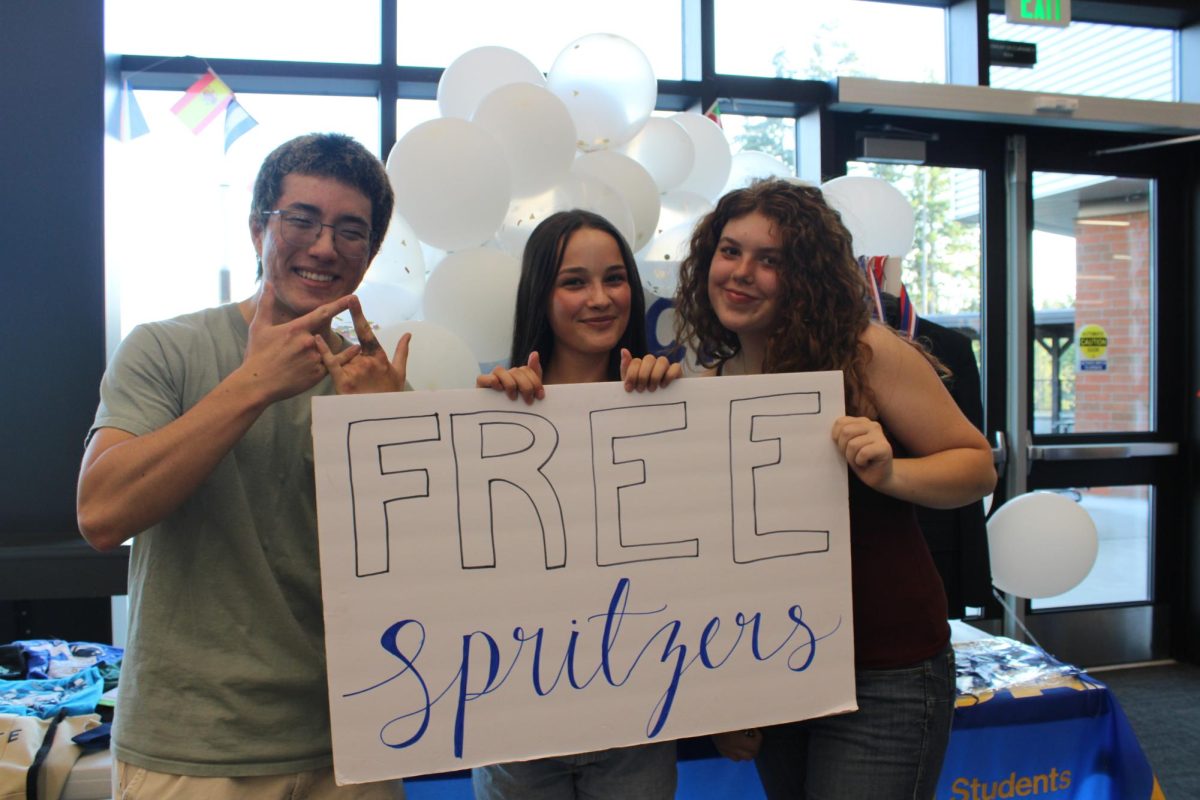 Kai Livingston (left), Annika Pexton (center), and Payton Broga (left) promote the Distributive Education Clubs of America to students at Maze Day.