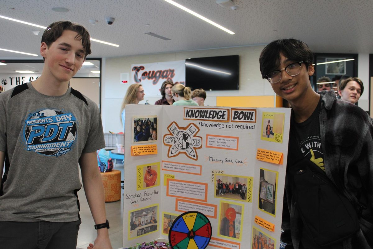 Alexander Steffen (left) and Matthew Manzano (right) stand beside their trifold.