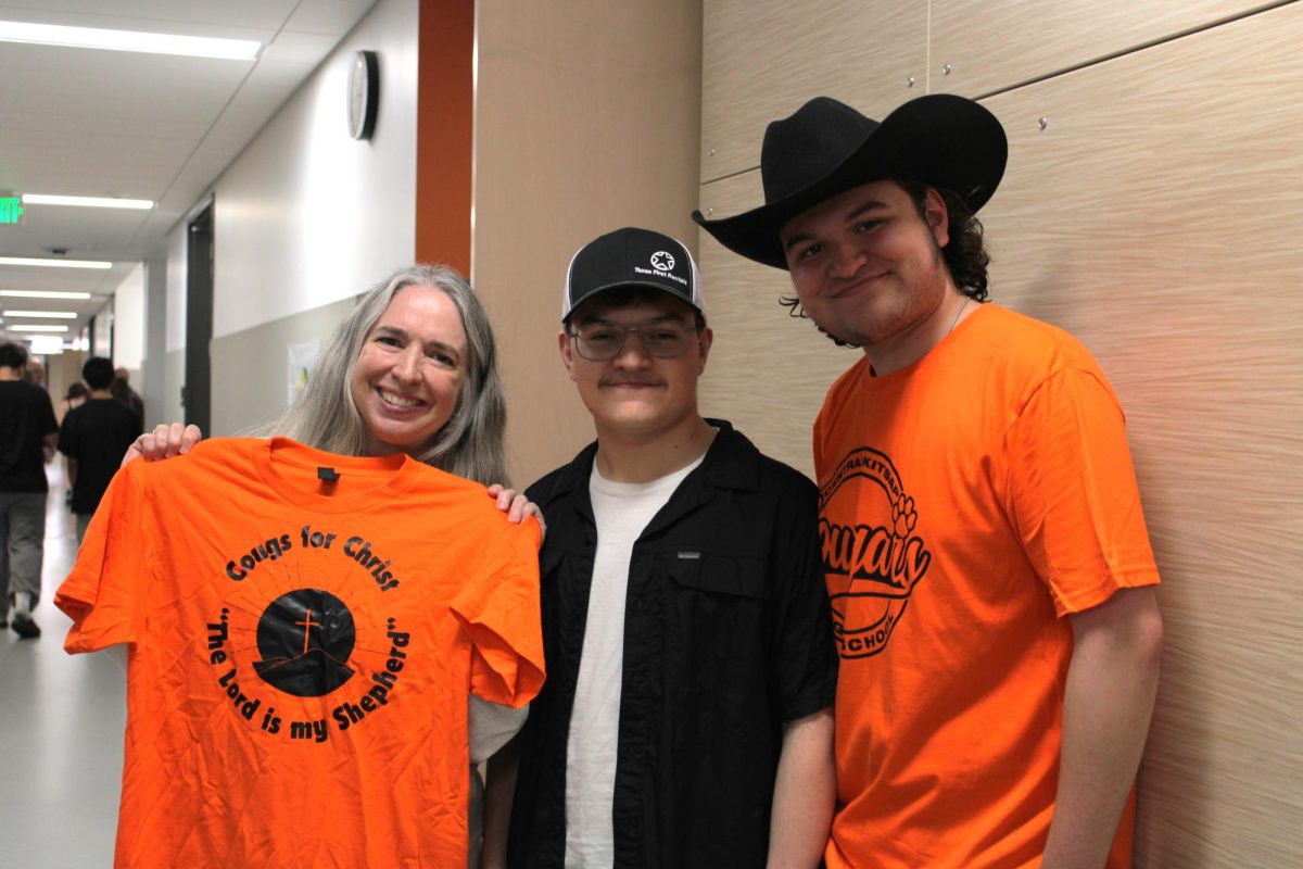 Eileen Beck (left), Tyler Smith (center), and Lucas Smith (right) promote the newly started club Cougs 4 Christ.