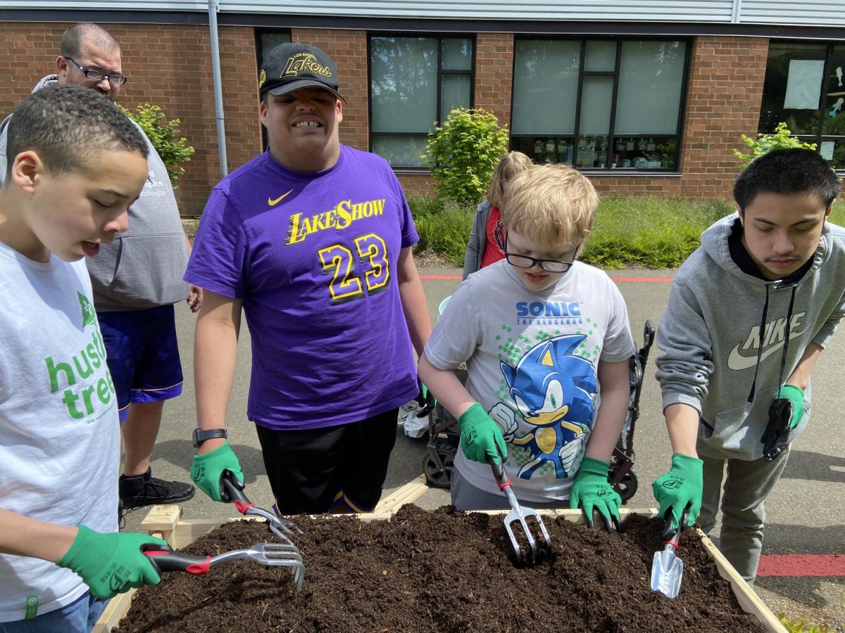 Students within the Independent Living Skills Class level out dirt for their garden bed. (Provided by Bridget Hardiman)